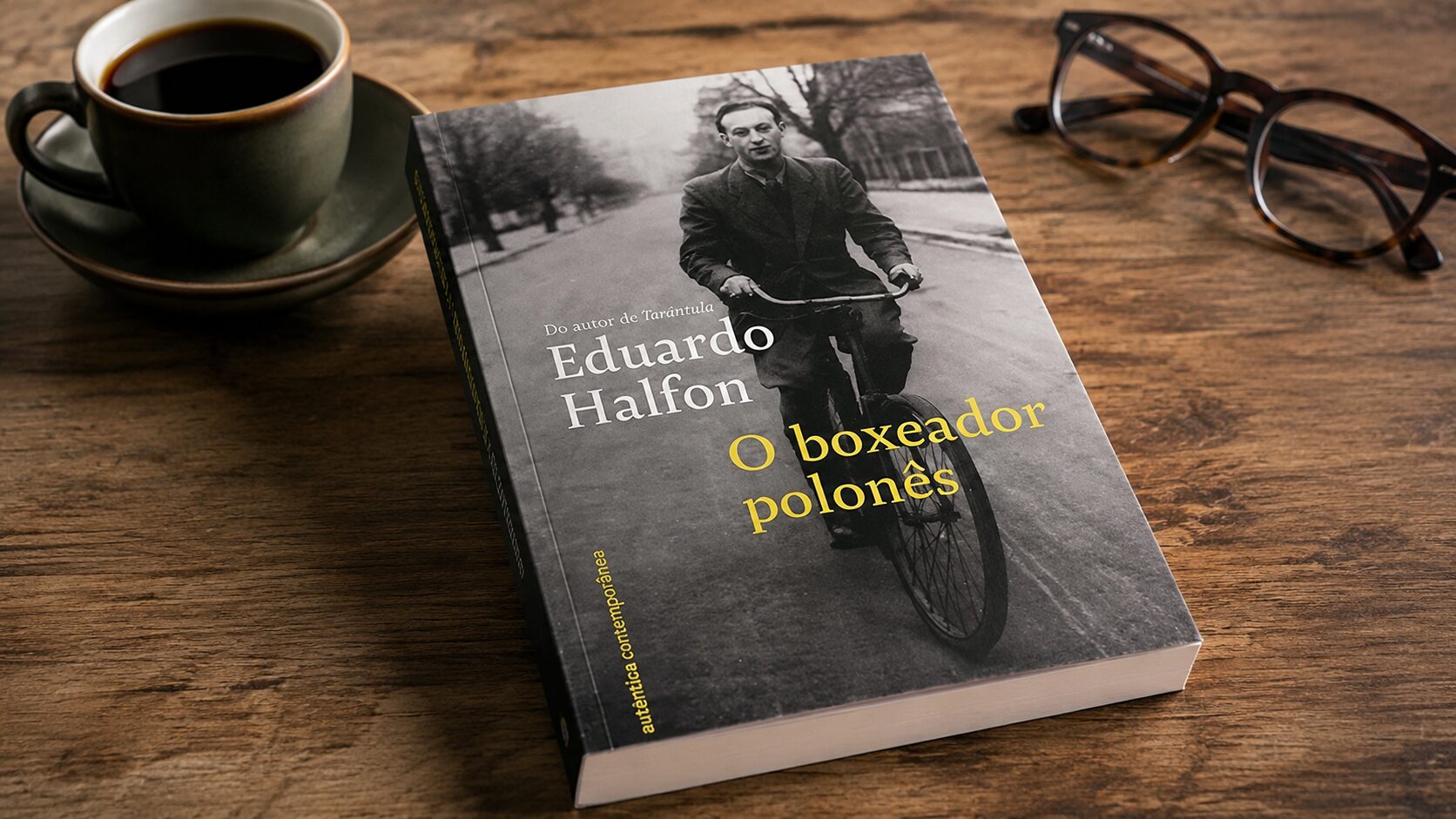 Livro O boxeador polonês, de Eduardo Halfon, sobre uma mesa de madeira com uma xícara de café e óculos
