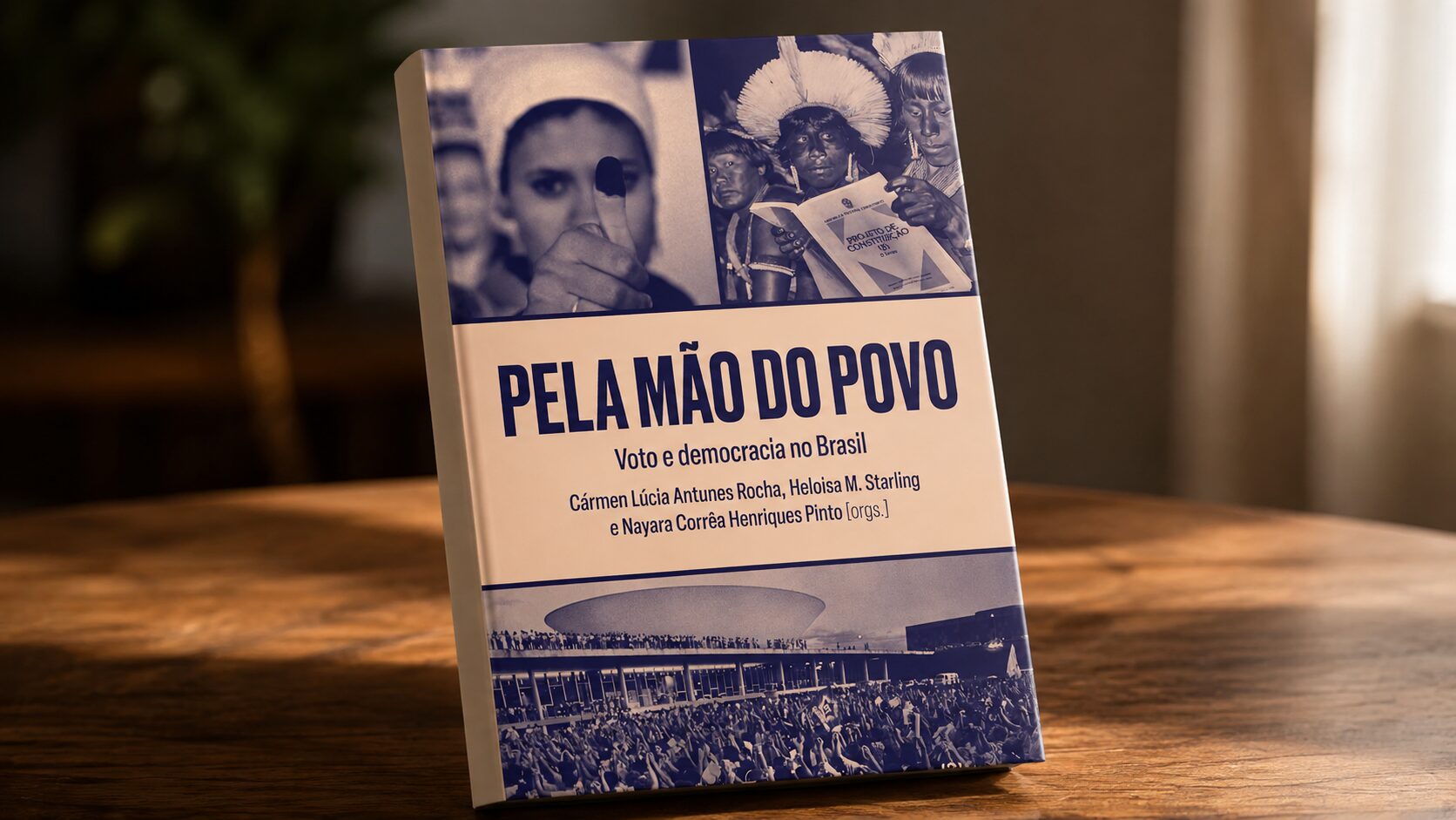 Livro Pela mão do povo apoiado sobre uma mesa de madeira
