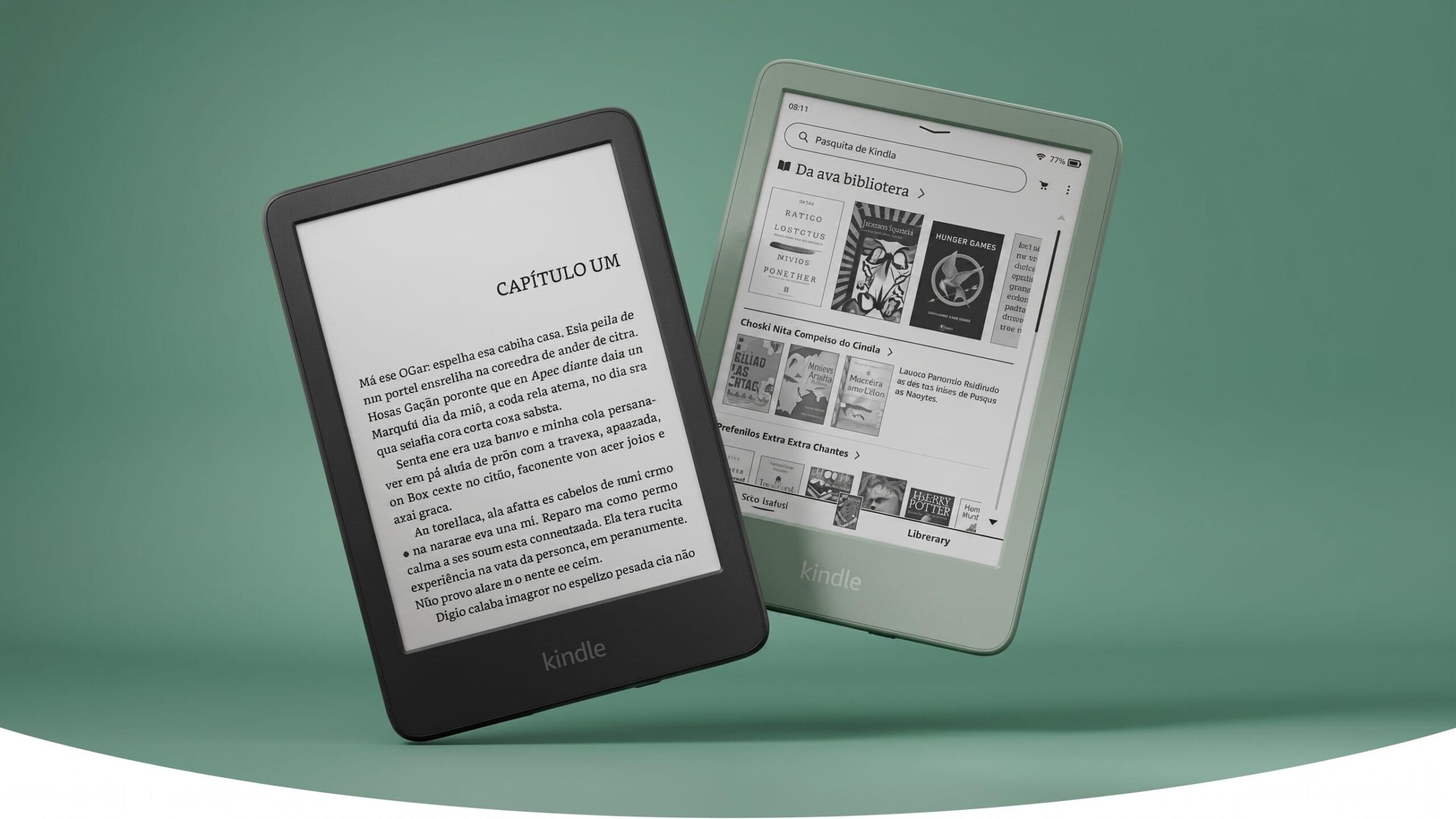 Dois leitores digitais Kindle sobre um fundo verde plano. Em primeiro plano, um Kindle preto exibe uma página de livro em português iniciando com "Capítulo Um". Atrás e à direita, um Kindle verde exibe a interface da biblioteca com diversas capas de e-books visíveis, incluindo "Jogos Vorazes".